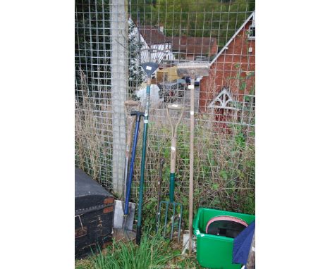 A selection of garden equipment including, fork, rake, and lawn edger etc.