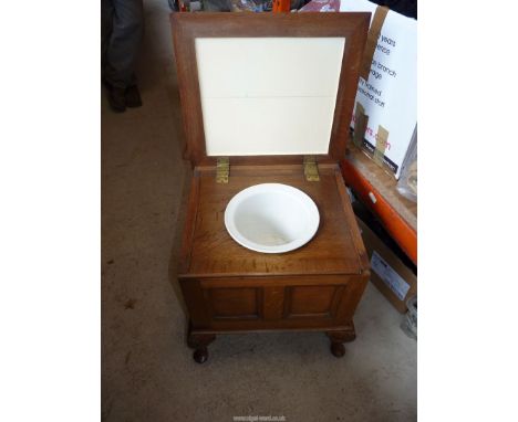 A box Commode on turned legs, furnished.