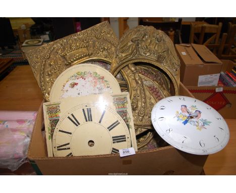 A quantity of brass, enamel and wooden clock faces and surrounds.