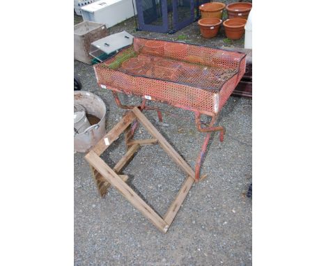 A wooden adjustable Trestles and a mesh trough on stand.