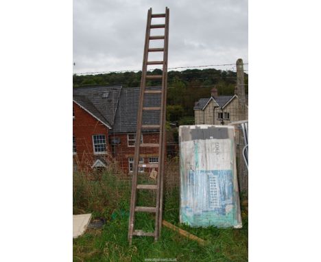Fourteen rung wooden extension ladder with cross bands.