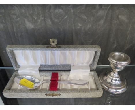 A small single candlestick and a cased silver spoon 