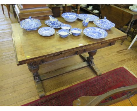 An oak draw leaf table, the rectangular top with carved cup and cover supports on bracket feet joined by a stretcher 122cm x 