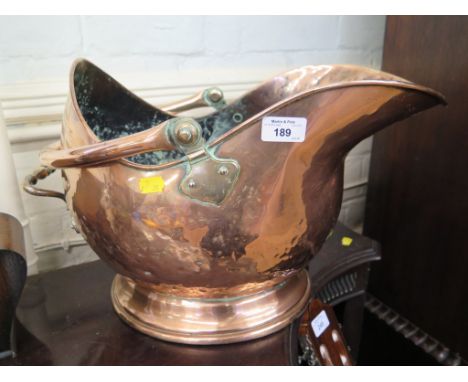 A copper helmet shaped coal scuttle