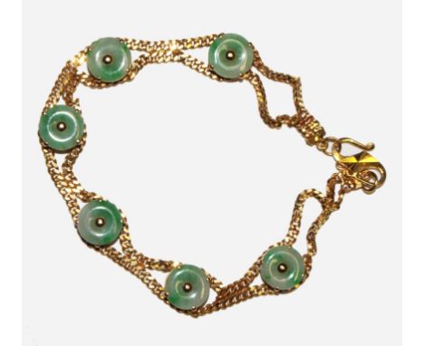 A gold bracelet set with green jade plaques