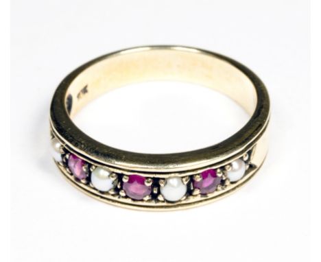 A gold pearl and three ruby band ring, size O