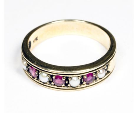 A gold pearl and three ruby band ring, size O