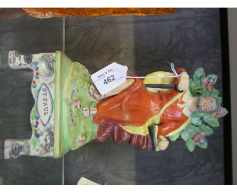 An early 19th century Staffordshire figure of St. Paul, seated with a dagger and a book, on a titled square base with bracket