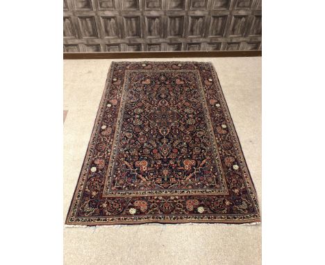 KASHAN BORDERED RUG, decorated with central medallion within a floral filled field, on a blue ground, 210cm x 133cm