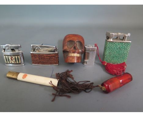 A quantity of Smokers ephemera including four lighters and a carved hardwood pipe in the form of a skull and a Beacon shagree