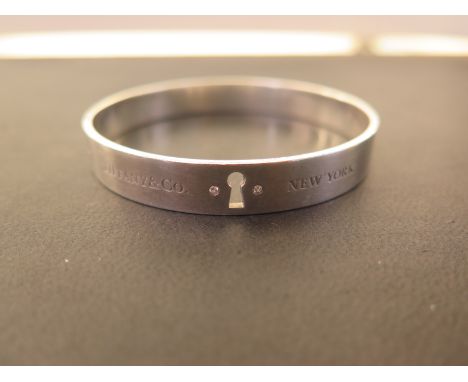 TIFFANY & CO a 'key hole' bangle - With two diamond highlights - Stamped 925 - Inner diameter 6.2cms - Weight approx 1.05ozt
