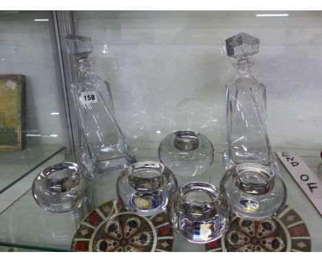A PAIR OF DECANTERS, AND FIVE KENNETH TURNER TEA LIGHT HOLDERS. 