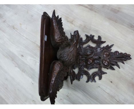 A 19th C. OAK WALL BRACKET, THE SHELF SEATED ON THE BACK OF A SPREAD EAGLE PERCHED ABOVE TWO PAIRS OF FRUIT.&nbsp; &nbsp;H 50