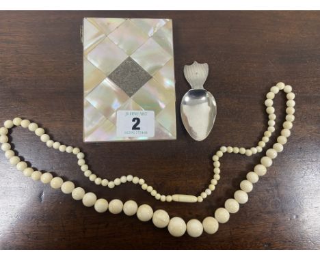 A MOTHER OF PEARL AND SILVER MOUNTED CARD CASE A CONTINENTAL SILVER CADDY SPOON, AND A STRING OF IVORY BEADS.