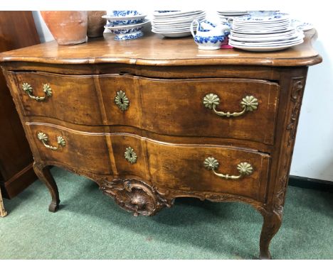 AN 18th C. PROVINCIAL FRENCH WALNUT COMMODE WITH TWO WAVY FRONTED DRAWERS BETWEEN CARVED FOLIAGE AND ABOVE FURTHER CARVING CE