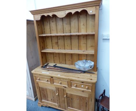 A MODERN PINE DRESSER. THE ENCLOSED TWO SHELF BACK OVER THREE DRAWERS AND TWO DOORS TO THE BASE.   W 122 x D 50 x H 196cms. 