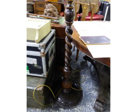 AN OAK STANDARD LAMP SPIRAL TURNED ABOVE THE CIRCULAR FOOT.