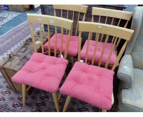 A SET OF FOUR 20th C. BEECH KITCHEN CHAIRS, BROAD TOP RAILS OVER THE STICK BACKS, SOLID SEATS AND CYLINDRICAL LEGS