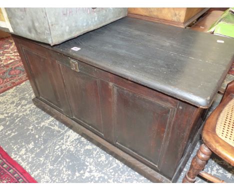 A 20th C. BLACKENED OAK COFFER WITH THREE PANEL FRONT.   W 98 x D 49 x H 55cms.