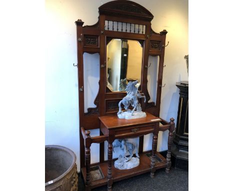 A LATE VICTORIAN MAHOGANY MIRROR BACKED HALL STAND,THE BACK WITH AN ARRANGEMENT OF BRASS COAT HOOKS ABOVE A SHELF OVER A DRAW