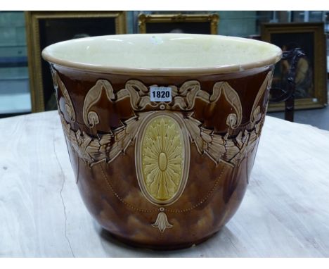 A LATE 19th C. MAJOLICA PLANTER, THE BROWN GLAZED EXTERIOR WITH YELLOW PATERAE IN RELIEF SUSPENDED FROM PINK RIBBONS AND HUNG