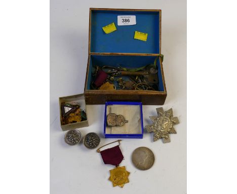 Box of regimental cap badges, coins, tokens, clock winders, pin badges etc