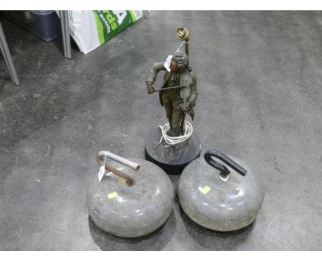 Two curling stones and vintage lamp base formed as a man playing a violin