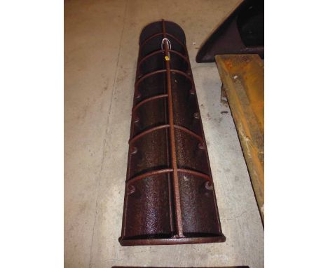 A horizontal cast iron pig trough with dividers