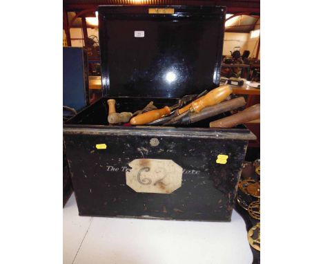 A metal harness trunk containing various Vintage equine tools