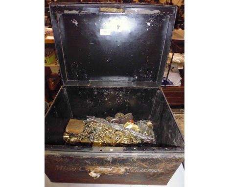 A metal harness trunk containing various horse brasses