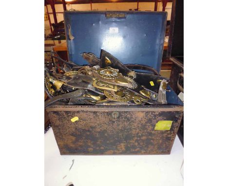 A metal harness trunk containing large quantity of horse brasses on leather straps