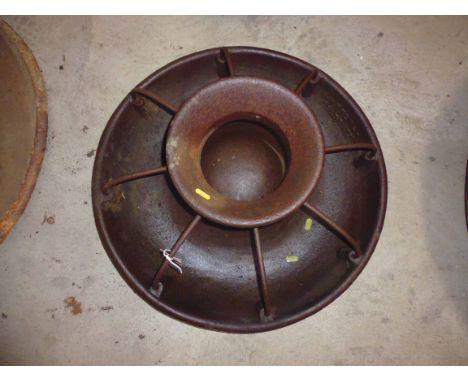 A medium round cast iron pig trough with dividers
