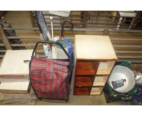 A wooden shelf, a shopping trolley and a waste bin containing an umbrella etc.