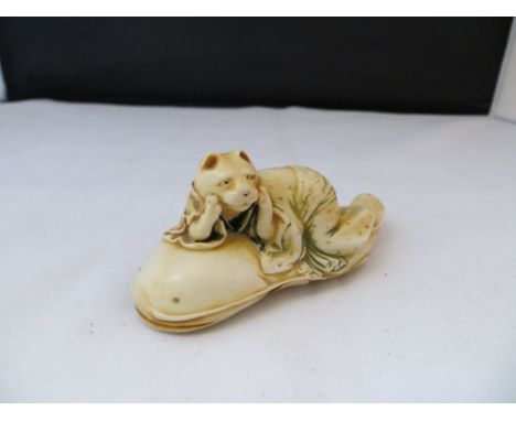Oriental bone carving of cat on fish.