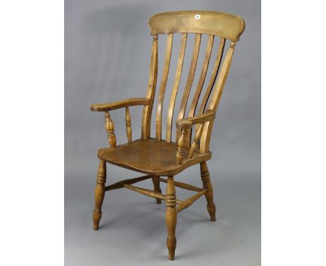 A Victorian beech lath-back elbow chair with a hard seat, &amp; on turned legs with spindle stretchers.