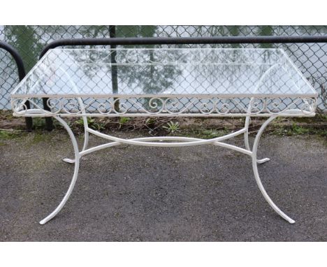 A white painted wrought-iron garden table inset tempered-glass plate to the rectangular top, with a pierced frieze &amp; on f