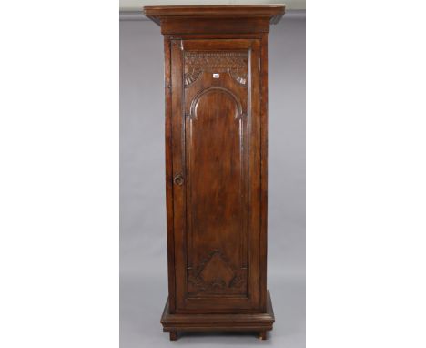 A reclaimed teak tall narrow upright cupboard with a moulded cornice, fitted three shelves enclosed by a carved panel door, &