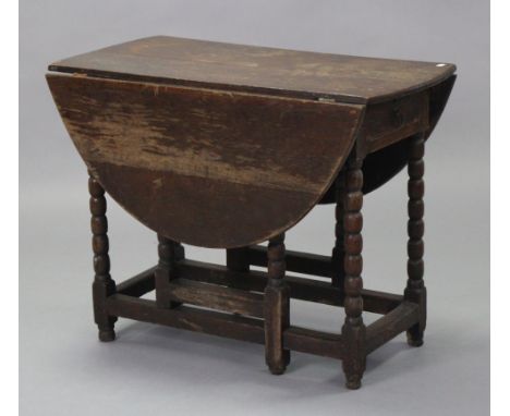 An 18th century oak gate-leg table with oval top, on bobbin-turned supports with plain stretchers, fitted end drawer, 36” wid