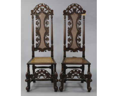 A pair of William &amp; Mary style oak tall-back side chairs with cane panelled back &amp; seats, on carved legs with turned 