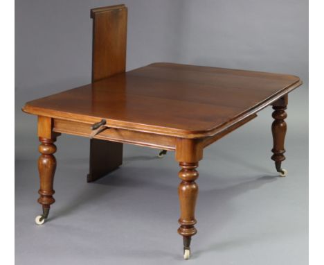 An early Victorian mahogany extending dining table with wind-out action &amp; two additional leaves, on slender turned balust