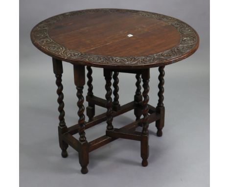 A small oak oval gate-leg table with a carved foliate border, &amp; on barley-twist legs &amp; turned feet with plain stretch