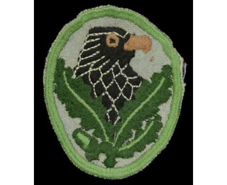 A Wehrmacht Sniper’s Badge Third Class. A machine embroidered patch on pale grey felt, black cotton eagle’s head and crossed 