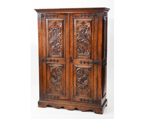VICTORIAN CARVED OAK PRESS CUPBOARD
with panelled doors on cast iron hinges and bracket feet, 179cm high, 125cm wide
