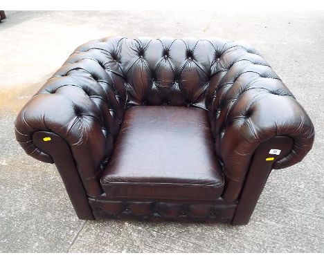 A Chesterfield Armchair, brown upholstered with button back arms and seat, 67 cm x 100 cm x 83 cm 