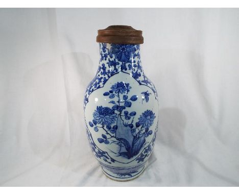 A 19th century Chinese blue and white vase decorated with peony issuing from rockwork, wooden lamp fitting to top, not drille