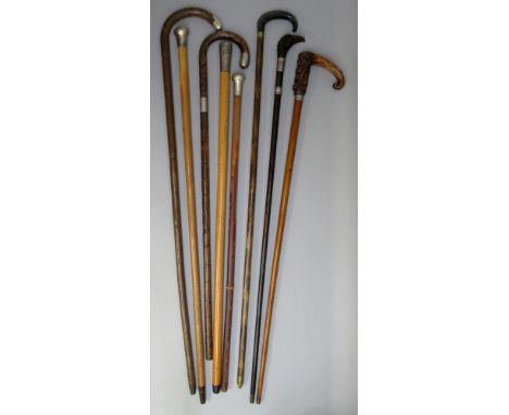 A COLLECTION OF SEVEN WALKING STICKS INCLUDING A C19th INDIAN SILVER HANDLED MALACCA WALKING STICK (L: 85cm), AND A SILVER HA