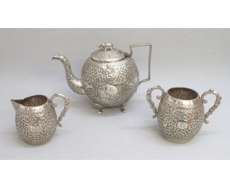 LATE C19th INDIAN SILVER THREE PIECE TEASET COMPRISING A SPERICAL TEAPOT WITH ALL OVER CHASED AND EMBOSSED SCROLLING DECORATI