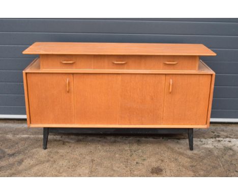 A retro vintage 1950s mid century E Gomme G-Plan light oak 'Librenza' sideboard raised on 4 black legs set on brass feet. 4-d