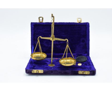 A cased set of brass portable scales with weights as large as 10 grams. 