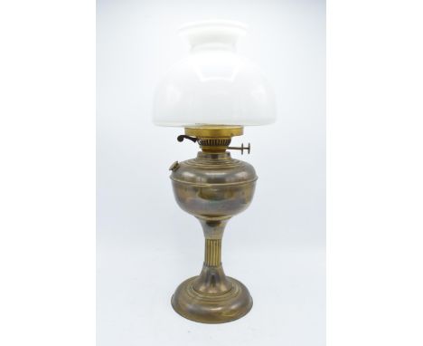 An early 20th century brass oil lamp with column effect body with associated glass shade. 50cm tall. In good condition though